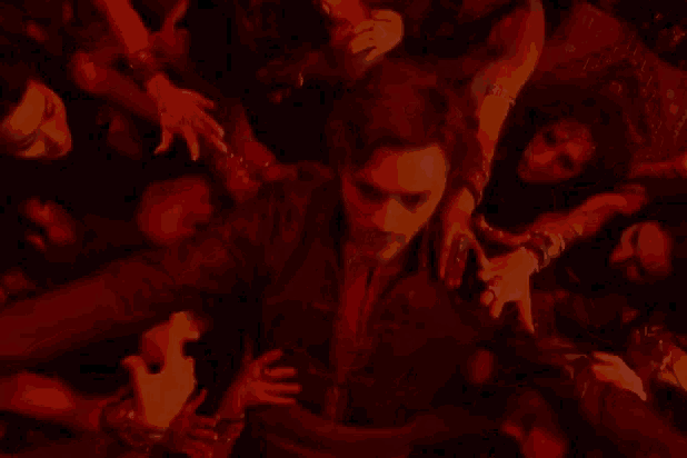 a man is surrounded by a bunch of people in red