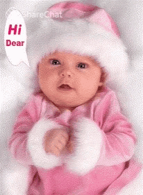 a baby is wearing a pink outfit and a white hat and says hi dear