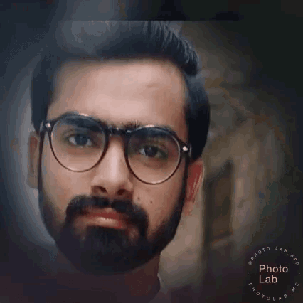 a man with a beard and glasses is looking at the camera with his eyes closed .