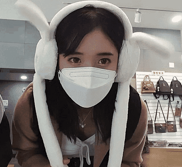 a woman wearing a mask and bunny ear headphones