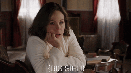 a woman in a white sweater is sitting in a chair with her hand on her chin and the words big sigh below her