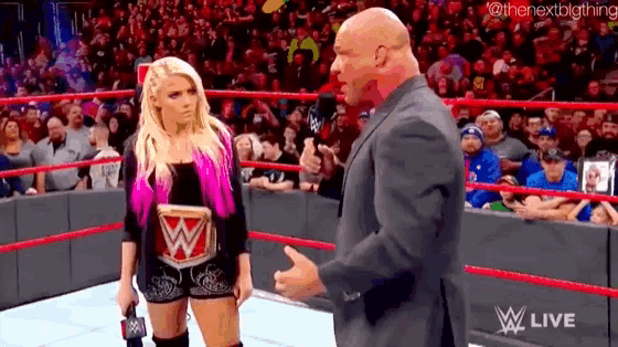 a man and a woman are standing in a wrestling ring .