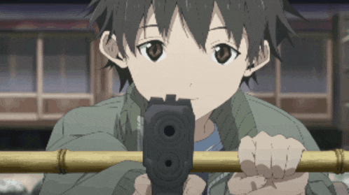a young boy is holding a gun and pointing it at the camera