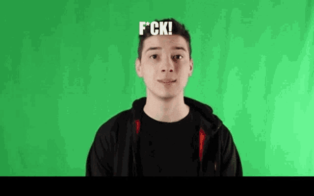 a young man is standing in front of a green screen and making a face .