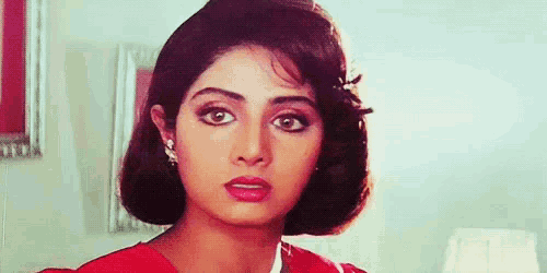 a close up of a woman 's face with a bob hairstyle and earrings .
