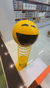 a yellow ball with a smiley face on it is on a spring