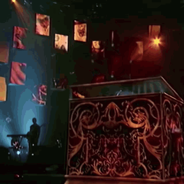 a silhouette of a man playing a keyboard in front of a display of images on a wall
