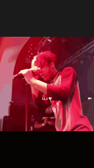 a man is singing into a microphone on stage .