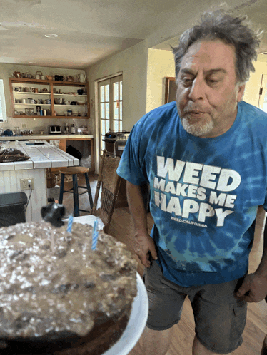 a man wearing a shirt that says " weed makes me happy "