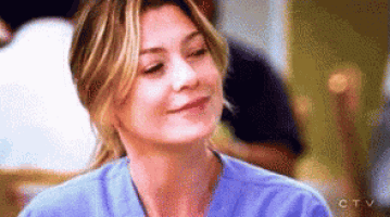 a woman in a blue scrub top is smiling .