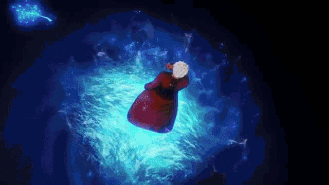 a person in a red dress is floating in the air in a dark room surrounded by blue water .