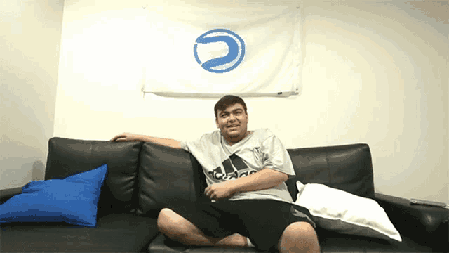 a man sits on a couch in front of a flag that says ' u ' on it