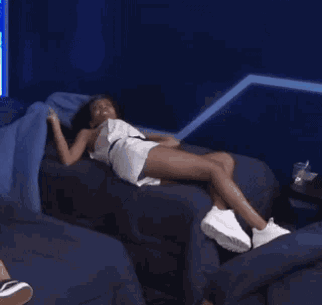 a person laying on a bed with a blue comforter