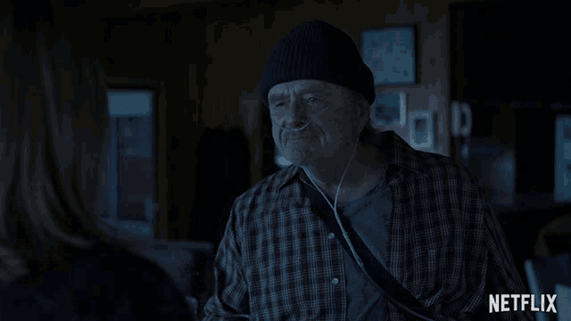 a man wearing a beanie and ear buds is talking to a woman and the words to life are visible