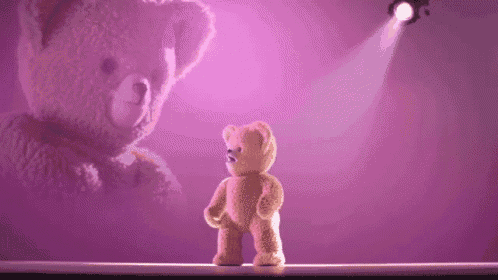 a teddy bear is standing in front of a purple background and a spotlight .