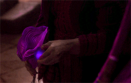a close up of a person 's hand touching a purple object .