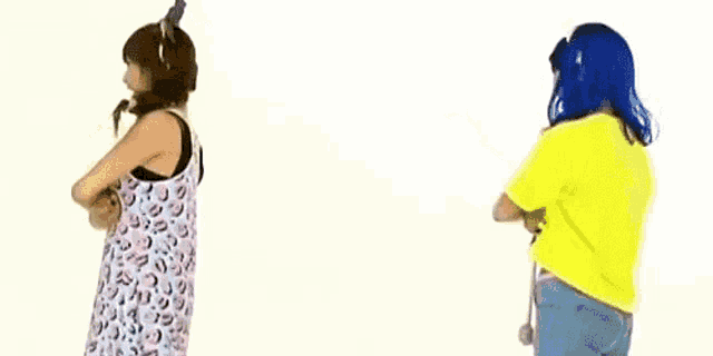 two women are standing next to each other and pointing at each other .