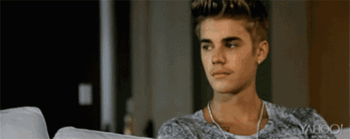 justin bieber is sitting on a couch wearing headphones and a shirt that says yahoo