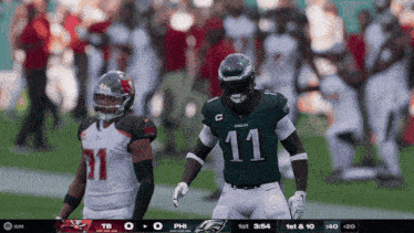 a football player with the number 11 on his jersey stands on the field