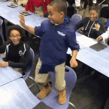 a young boy wearing a blue jacket with the word columbia on it stands in front of a group of children