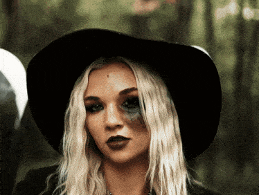 a woman wearing a black hat has a black eye