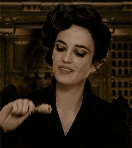 a woman is eating a piece of meat with her mouth open
