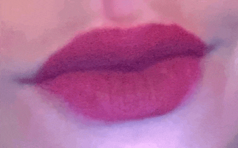 a close up of a woman 's lips with red hearts coming out of it