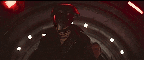 a man in a red helmet is walking through a tunnel with a woman behind him .