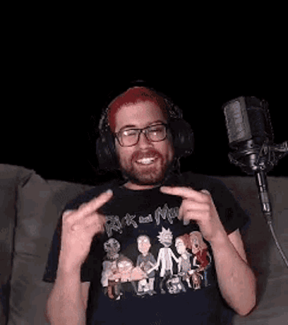 a man wearing headphones and a rick and morty shirt is sitting in front of a microphone