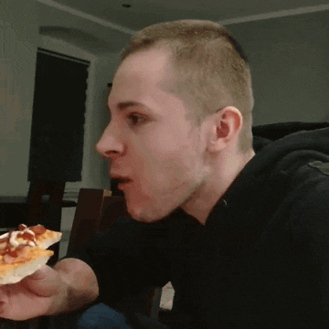 a man in a black shirt is eating a pizza