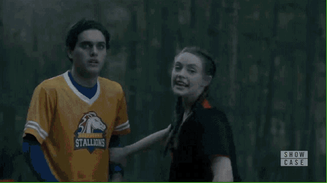 a man and a woman are standing next to each other in a show case scene