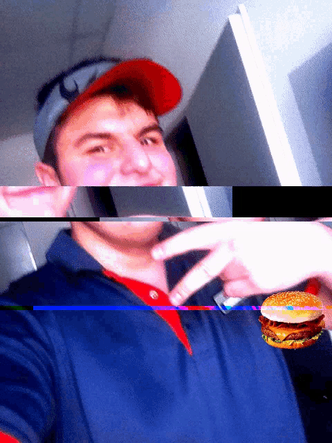 a man wearing a red hat and a blue shirt holds a hamburger