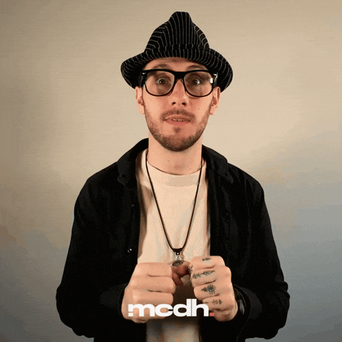 a man wearing glasses and a hat with the word mcdh on the bottom