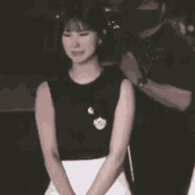 a woman wearing headphones and holding a microphone is standing on a stage in a dark room .
