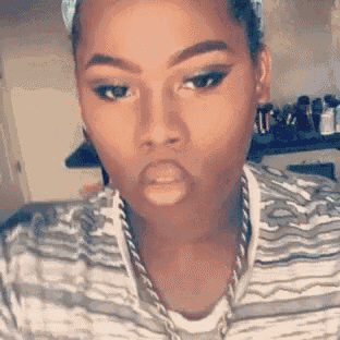 a woman is taking a selfie with her mouth open and wearing a striped shirt .