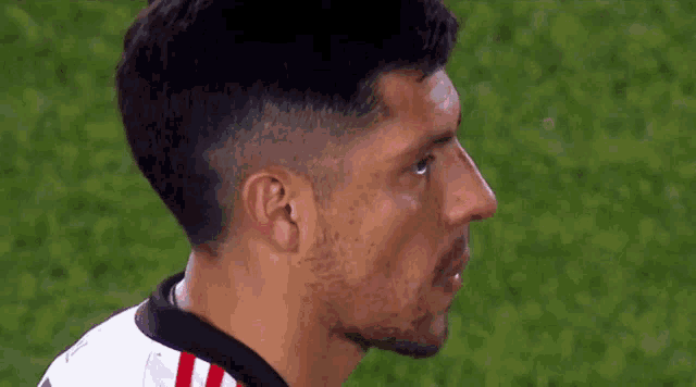 a close up of a soccer player 's face on a field