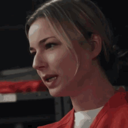 a close up of a woman 's face in a red uniform