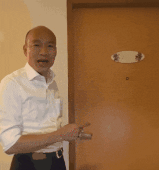 a man standing in front of a door that has a sign on it that says j.m.