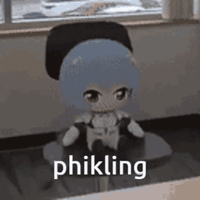 a stuffed doll is sitting in a chair with the words phikling written on it .
