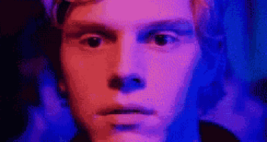 a close up of a man 's face with a purple and blue background .