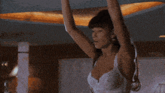 a woman in a white bra is dancing in a room