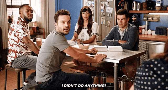 a group of people are sitting around a table with one man saying i did n't do anything
