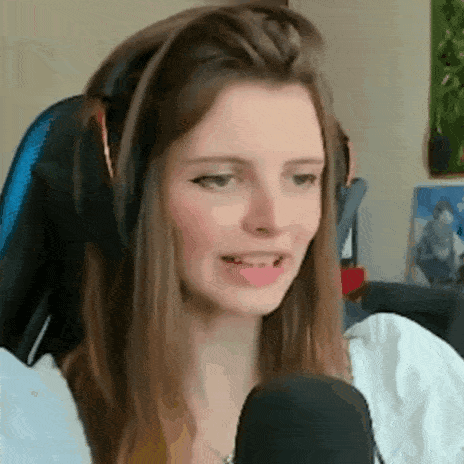 a woman wearing headphones and a white shirt is sitting in front of a microphone .