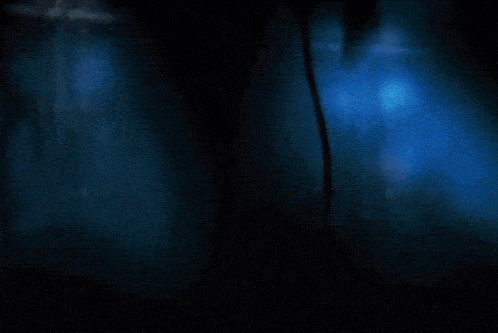 a dark room with a blue light shining through the ceiling