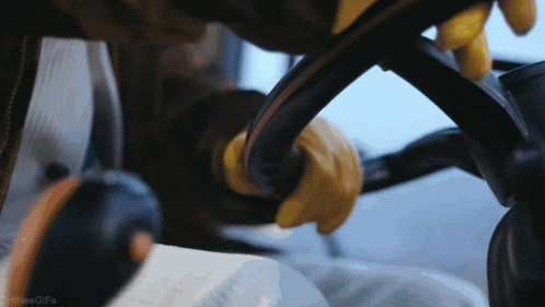 a close up of a person holding a steering wheel with the words shineegifs below