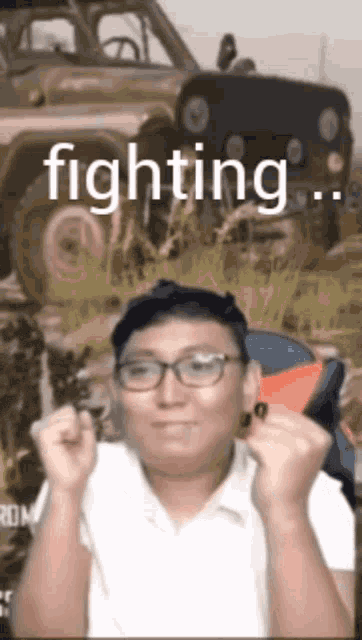 a man wearing glasses is standing in front of a jeep that says fighting on it