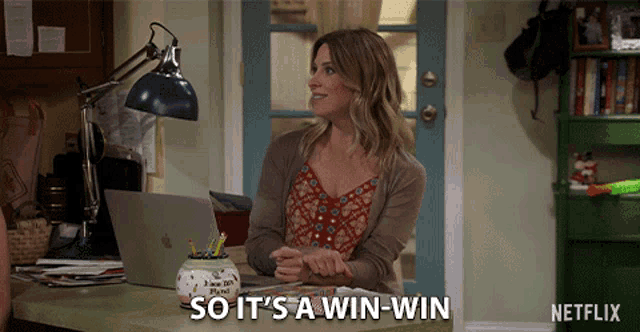 a woman is sitting at a desk with a laptop and says " so it 's a win-win "