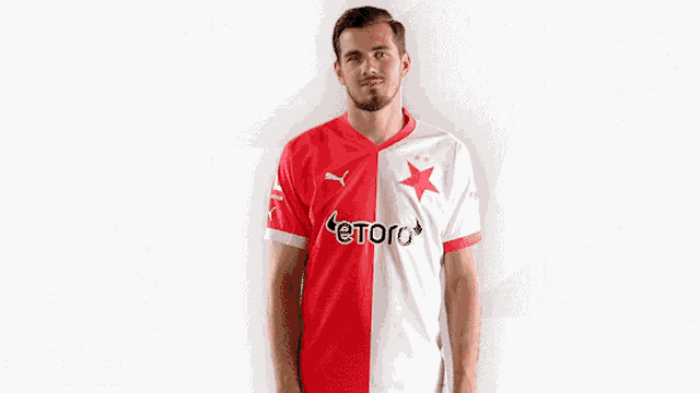 a man is wearing a red and white jersey that says etoro on it