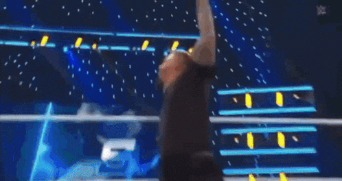 a wrestling match is going on in front of a crowd and the word wwe is on the wall