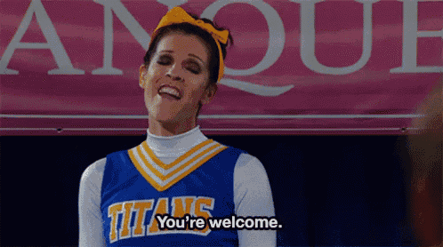 a cheerleader wearing a titans uniform is standing in front of a pink sign .